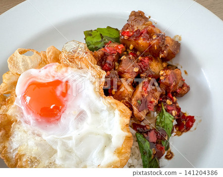 Rice topped with crispy pork belly with Thai basil and fried egg Rice topped with crispy pork belly with Thai basil and fried egg 141204386