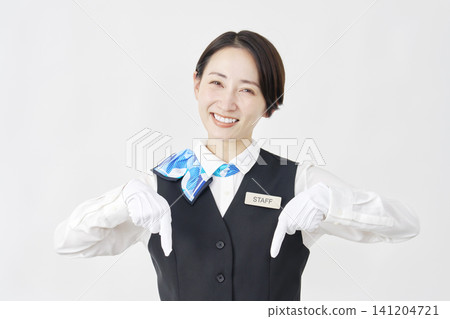 Female staff member pointing downwards; receptionist/bus guide; white background. Female staff member pointing downwards; receptionist/bus guide; white background. 141204721