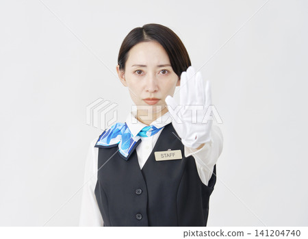 Female staff member, receptionist/bus guide, striking a stop pose against a white background. Female staff member, receptionist/bus guide, striking a stop pose against a white background. 141204740