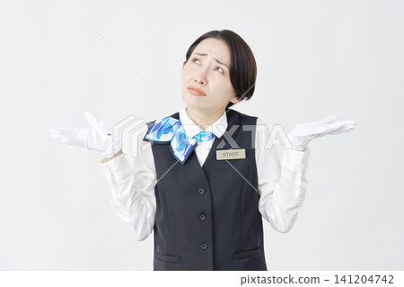 Female staff member, receptionist/bus guide, raising her hands in a helpless pose, against a white background. Female staff member, receptionist/bus guide, raising her hands in a helpless pose, against a white background. 141204742