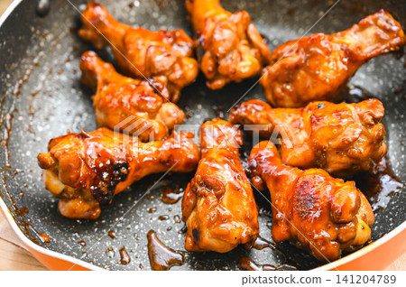 Teriyaki chicken drumsticks in a frying pan Teriyaki chicken drumsticks in a frying pan 141204789
