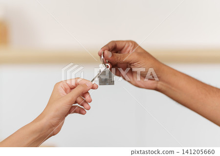 Cropped hands passing house key for real estate and home ownership 141205660