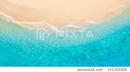 Top down aerial of curving wave edge between bright turquoise sea and smooth sand. Organic foam curve crossing tropical shoreline, graphic natural composition from above. Versatile drone background Top down aerial of curving wave edge between bright turquoise sea and smooth sand. Organic foam curve crossing tropical shoreline, graphic natural composition from above. Versatile drone background 141205808