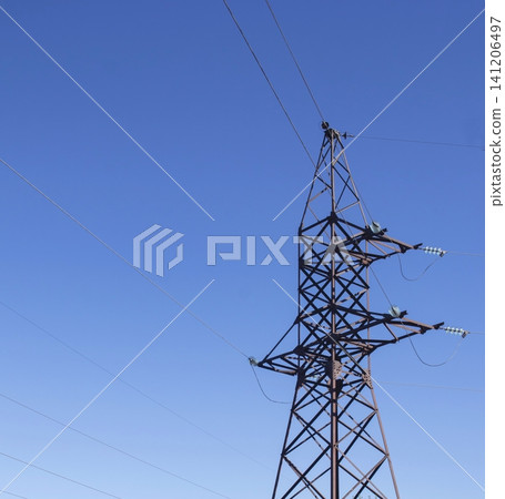 High-voltage power transmission towers against a blue sky background. Energy, electricity transmission tower. Power transmission pole with power lines and insulators. High-voltage power transmission towers against a blue sky background. Energy, electricity transmission tower. Power transmission pole with power lines and insulators. 141206497