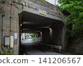 A tunnel beneath the road with a roadway and sidewalk that is lit even during the daytime. 141206567