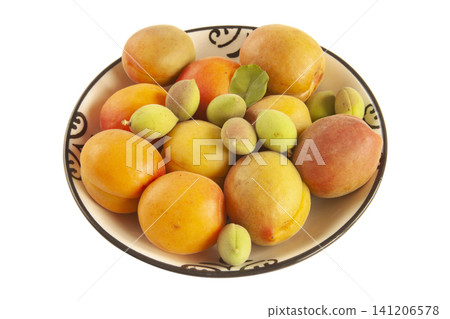 green fresh apricots and ripe apricots in the plate 141206578