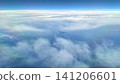 Island silhouette visible through a break in the clouds | Aerial view from inside the plane Island silhouette visible through a break in the clouds | Aerial view from inside the plane 141206601