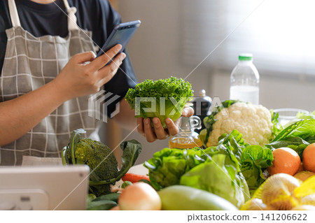 Middle Aged Asian People Checking Nutrition Information While Choosing Vegetables Middle Aged Asian People Checking Nutrition Information While Choosing Vegetables 141206622