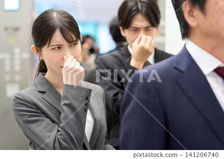Business people who are bothered by smells in elevators Business people who are bothered by smells in elevators 141206740