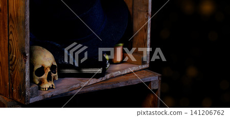 Spooky Halloween shelf with skull and witch hat, dark aesthetic and copy space of vintage aesthetic with background bokeh lights Spooky Halloween shelf with skull and witch hat, dark aesthetic and copy space of vintage aesthetic with background bokeh lights 141206762
