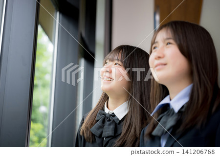 Japanese high school girls smile as they look towards the future; a close-up of their school life as they discuss their dreams and future paths together. Japanese high school girls smile as they look towards the future; a close-up of their school life as they discuss their dreams and future paths together. 141206768