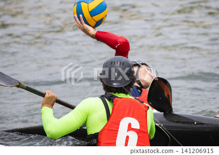 Two athletes engaged in canoe polo competition, one wearing a red jersey and the other in a green jersey, with a water polo ball in mid-air above the water Two athletes engaged in canoe polo competition, one wearing a red jersey and the other in a green jersey, with a water polo ball in mid-air above the water 141206915