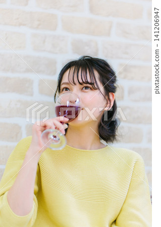 一位年輕女子在家喝紅酒 一位年輕女子在家喝紅酒 141206947