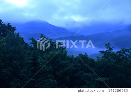 Mountain range covered in a sea of clouds Mountain range covered in a sea of clouds 141206983