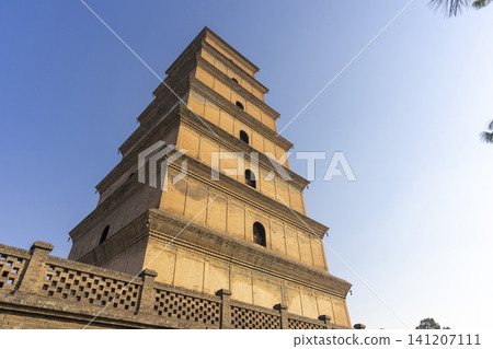 Xi'an, China - Dec 31, 2024 : View of Big Wild Goose Pagoda against blue sky in Xian, China on Dec 31, 2024. Xi'an, China - Dec 31, 2024 : View of Big Wild Goose Pagoda against blue sky in Xian, China on Dec 31, 2024. 141207111