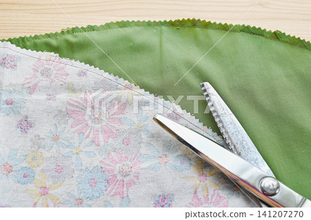 The process of finishing the curved edge of fabric with pinking shears. The process of finishing the curved edge of fabric with pinking shears. 141207270