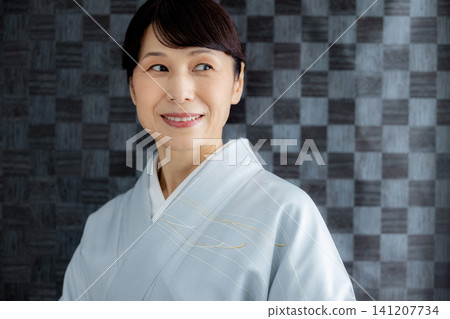 A woman getting dressed in a kimono 141207734