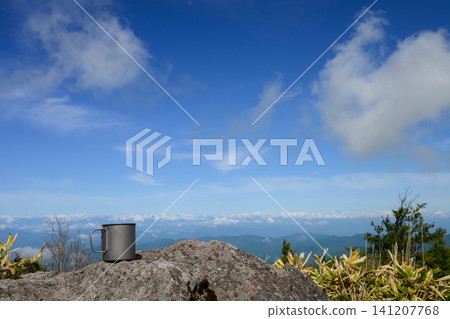 一隻鈦金屬杯放置在阿爾卑斯山殘雪覆蓋的山頂上 | 登山與戶外生活圖片 141207768