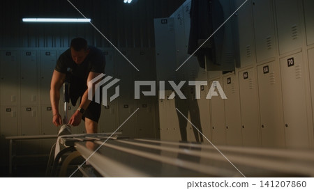 Adaptive Athlete with Leg Prosthesis Tying Shoelaces in Gym Locker Room Adaptive Athlete with Leg Prosthesis Tying Shoelaces in Gym Locker Room 141207860