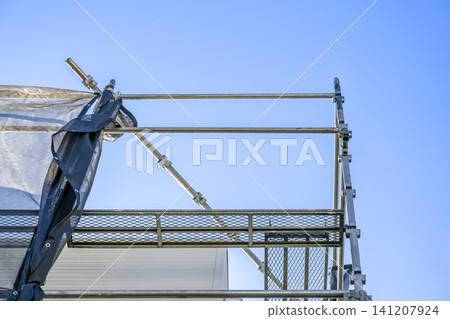 Temporary scaffolding and open sky for flat roof renovation work Temporary scaffolding and open sky for flat roof renovation work 141207924