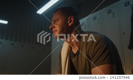 Athlete in Warm Lit Locker Room, Catching Breath After Intense Workout Athlete in Warm Lit Locker Room, Catching Breath After Intense Workout 141207946