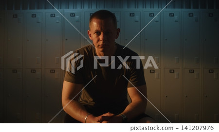Focused Man with Leg Prosthesis Stretching in Sunlit Modern Sports Dressing Room Focused Man with Leg Prosthesis Stretching in Sunlit Modern Sports Dressing Room 141207976