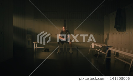 Resilient Man with Physical Disability Reflecting in Locker Room 141208006