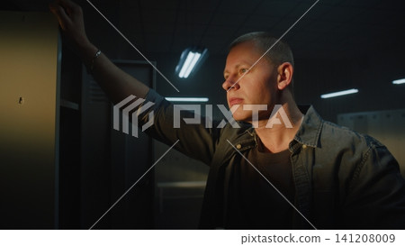 Focused Athlete Drinking Coffee and Looking Out Window in Sports Club Locker Room Focused Athlete Drinking Coffee and Looking Out Window in Sports Club Locker Room 141208009