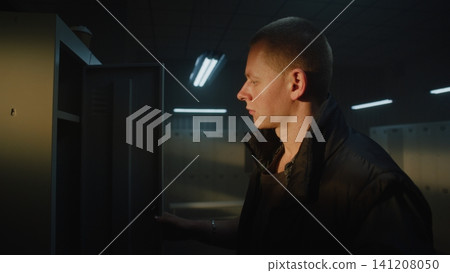 Focused Athlete Drinking Coffee and Looking Out Window in Sports Club Locker Room 141208050