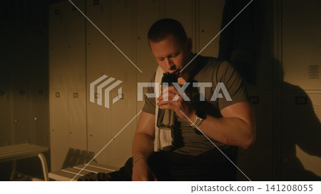 Athlete with Prosthetic Leg Resting in Sunlit Locker Room After Workout Athlete with Prosthetic Leg Resting in Sunlit Locker Room After Workout 141208055