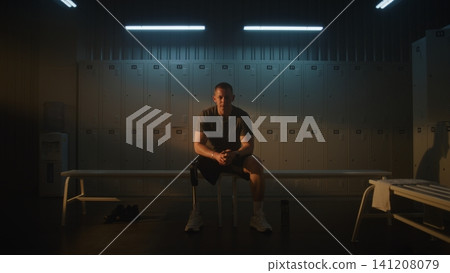 Determined Male Athlete with Prosthetic Leg Resting in Locker Room After Exercise Determined Male Athlete with Prosthetic Leg Resting in Locker Room After Exercise 141208079
