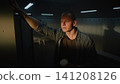 Pensive Young Man Leaning on Locker and Looking Window in Gym Dressing Room 141208126