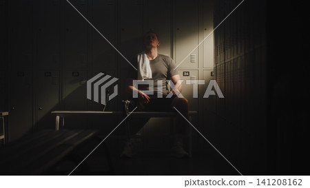 Professional Athlete with Leg Prosthesis Resting in Dressing Room Professional Athlete with Leg Prosthesis Resting in Dressing Room 141208162