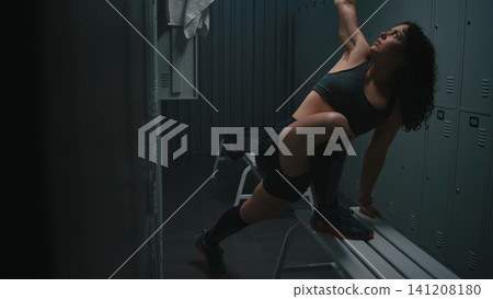 Female Athlete Doing Deep Lunges for Hip Mobility in Gym Locker Room Female Athlete Doing Deep Lunges for Hip Mobility in Gym Locker Room 141208180