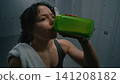 Exhausted but Determined Woman Resting in Dark Locker Room 141208182