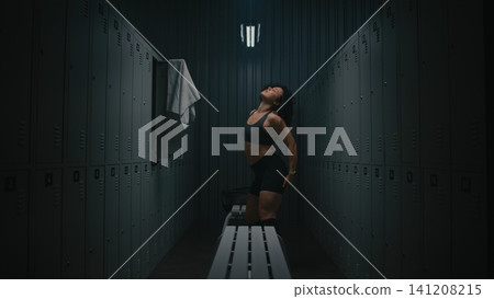 Athletic Curly Woman Dancing With Joy in Empty Locker Room Athletic Curly Woman Dancing With Joy in Empty Locker Room 141208215