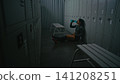 Strong Woman Going Through Moment of Despair But Not Giving Up in Empty Locker Room 141208251