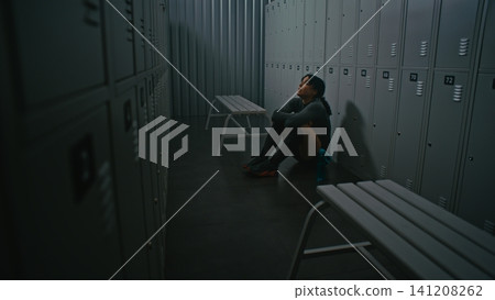 Strong Woman Going Through Moment of Despair But Not Giving Up in Empty Locker Room Strong Woman Going Through Moment of Despair But Not Giving Up in Empty Locker Room 141208262