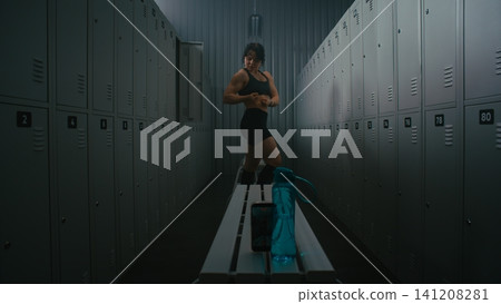 Female Fitness Influencer Recording Video of Flexing Muscles in Locker Room Female Fitness Influencer Recording Video of Flexing Muscles in Locker Room 141208281