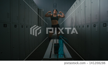 Female Fitness Influencer Recording Video of Flexing Muscles in Locker Room Female Fitness Influencer Recording Video of Flexing Muscles in Locker Room 141208286