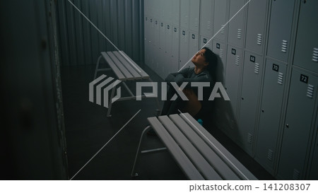 Female Athlete Sitting on Floor After Loss or Failed Training Female Athlete Sitting on Floor After Loss or Failed Training 141208307