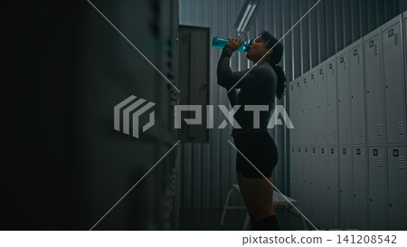 Female Athlete Putting on Long Sleeve and Leaving Locker Room for Training Female Athlete Putting on Long Sleeve and Leaving Locker Room for Training 141208542