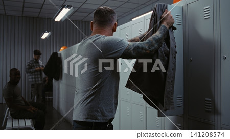 Diverse Factory Workers Laughing and Talking While Changing in Modern Industrial Locker Room Diverse Factory Workers Laughing and Talking While Changing in Modern Industrial Locker Room 141208574