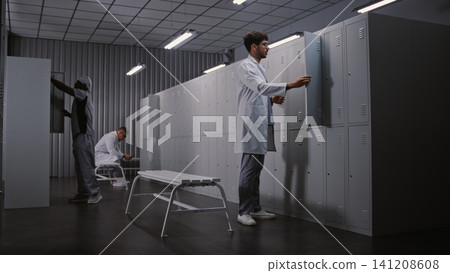Diverse Group of Doctors Changing Clothes in Hospital Locker Room After Long Medical Shift 141208608