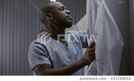 Tired Surgeon Rubbing Face in Medical Locker Room Tired Surgeon Rubbing Face in Medical Locker Room 141208618