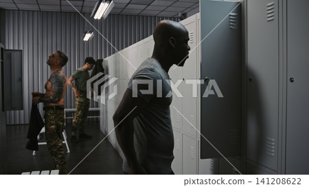 Military Shift Change, Soldiers Swapping Gear and Dressing in Base Locker Room Before Duty Military Shift Change, Soldiers Swapping Gear and Dressing in Base Locker Room Before Duty 141208622