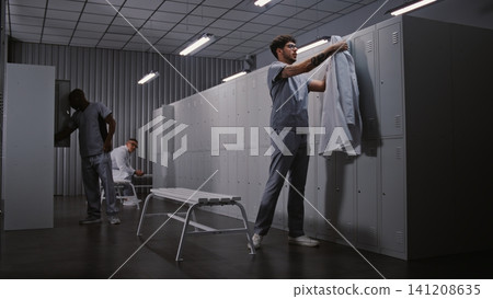 Diverse Group of Doctors Changing Clothes in Hospital Locker Room After Long Medical Shift Diverse Group of Doctors Changing Clothes in Hospital Locker Room After Long Medical Shift 141208635