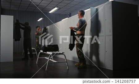 Soldiers Preparing for Mission and Dressing in Uniform at Military Base Locker Room Soldiers Preparing for Mission and Dressing in Uniform at Military Base Locker Room 141208757