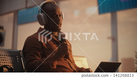 African American Businessman Putting on Headphones for Video Call at Airport African American Businessman Putting on Headphones for Video Call at Airport 141208813