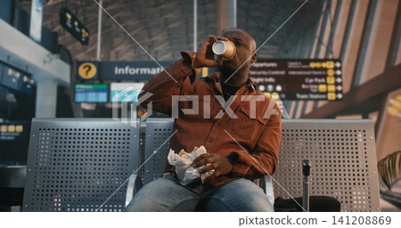 Male Traveler Having Sandwich and Coffee in Departure Lounge Male Traveler Having Sandwich and Coffee in Departure Lounge 141208869